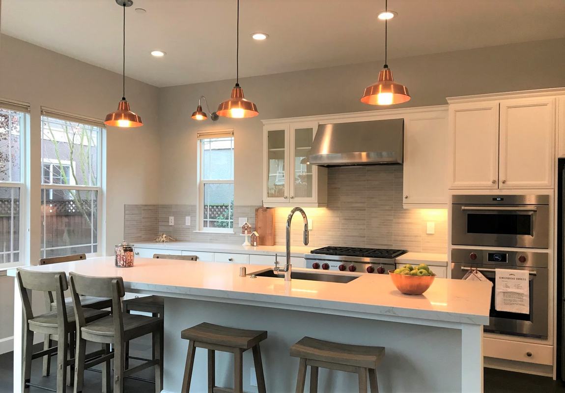 Copper pendant lighting over a custom kitchen island by Peak Property Electric