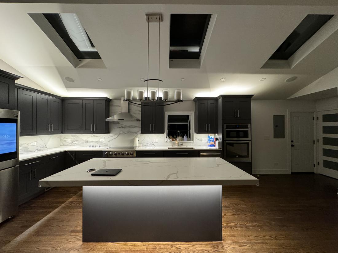 Custom kitchen lighting with skylights and cove lighting by Peak Property Electric