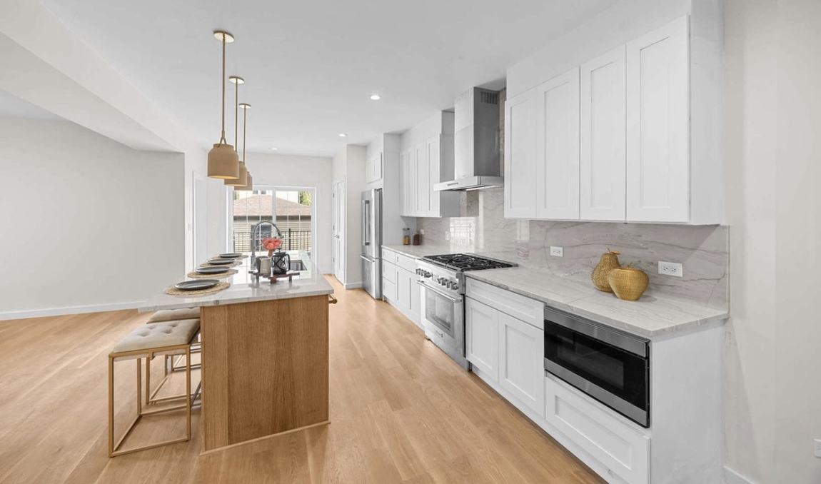 Recessed and pendant lighting in a finished white kitchen by Peak Property Electric